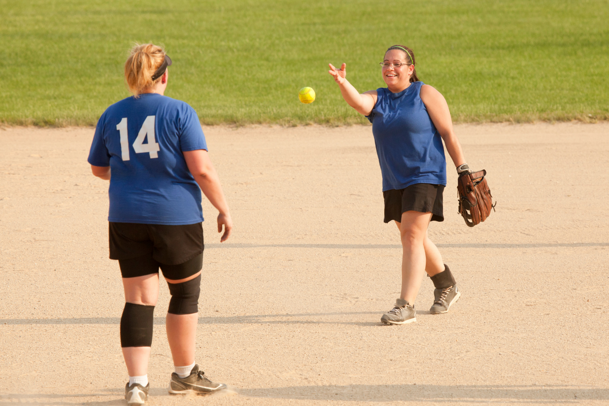 People enjoying a game of co-ed softball