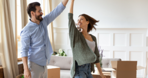 Happy Homewoners with changes in mortgage insurance premiums dancing in their home