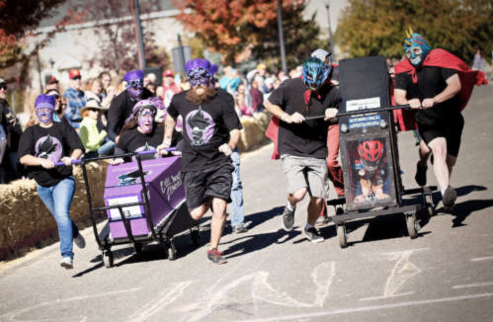 A photo of two teams racing coffins at the Main Street Gardnerville Fall Festival. 
