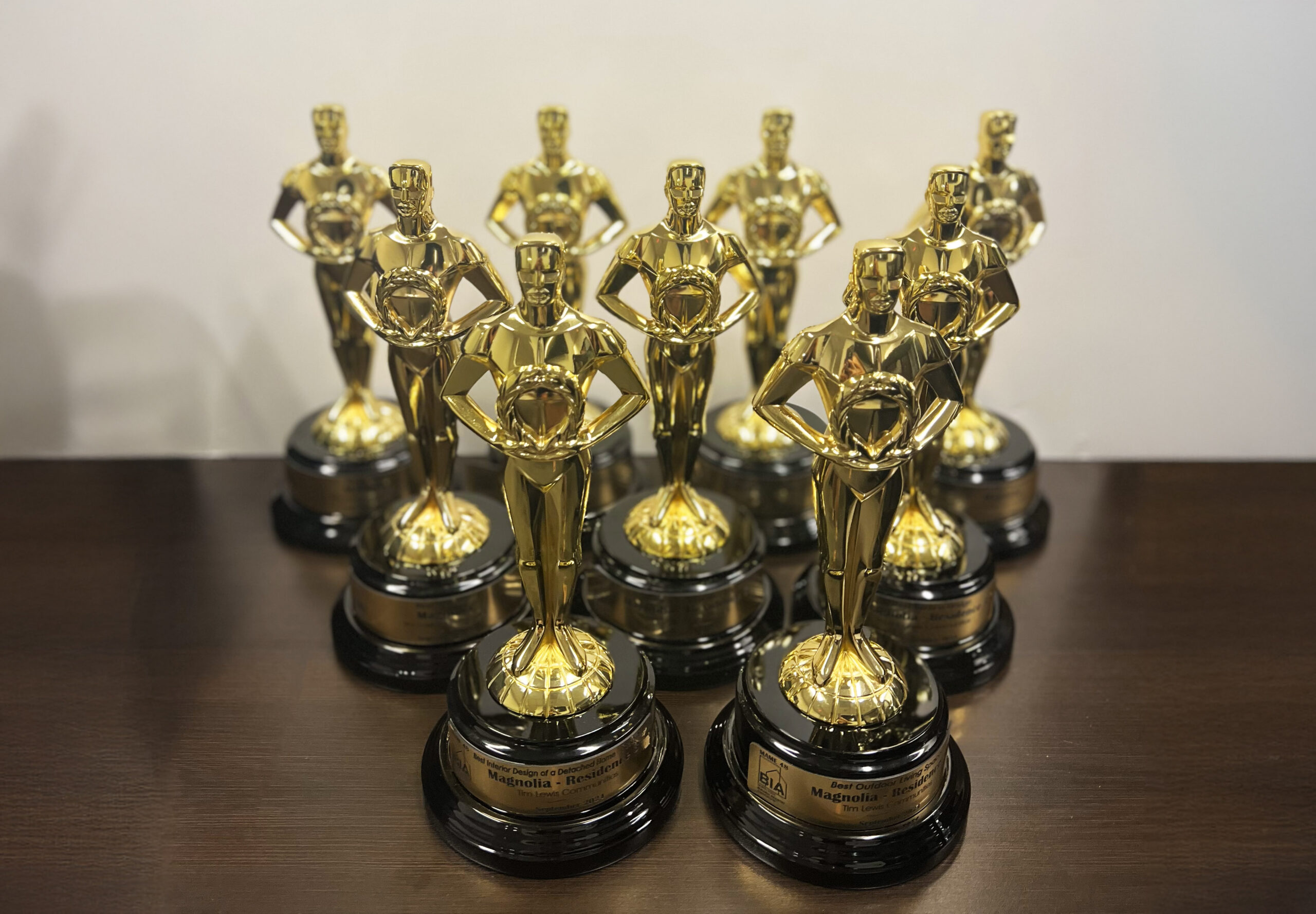 TLC-MAMA_Awards Nine golden trophies on a table in a triangular placement won by Tim Lewis homes at the MAMA Awards.